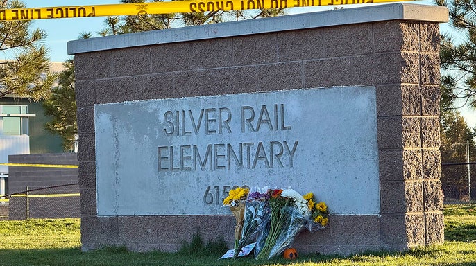 Flowers are placed beside a sign at Silver Rail Elementary School in Bend, Ore., on Friday, Oct. 16, 2026, a day after a deadly shooting.