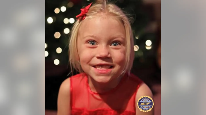 Summer Wells in a red dress with a red bow in her blonde hair