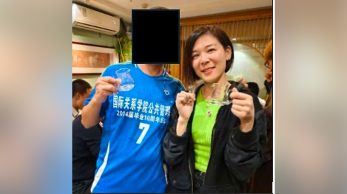 Wanying Zhang poses beside a man whose face is blacked out in a photo included in a federal complaint